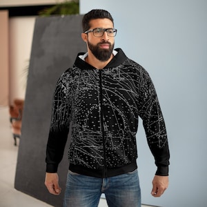Puede incluir: Sudadera con capucha negra con cremallera y diseño abstracto blanco. La sudadera presenta un patrón detallado de líneas y puntos blancos sobre un fondo negro. Tiene un forro interior blanco y una cremallera completa.