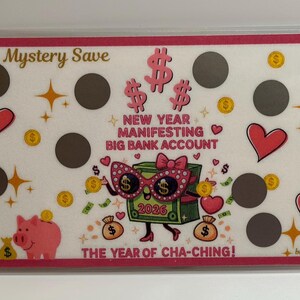 以下が含まれることがあります： 「Mystery Save」と「New Year Manifesting Big Bank Account」の文字が入った白とピンクの貯蓄トラッカー。ハート、星、コイン、サングラスをかけた漫画の貯金箱のデザイン。 「2026」の文字が見えます。