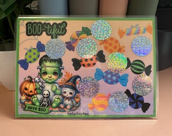 May include: A Halloween-themed card with a green monster, a witch, and candy. The card says "BOO-tiful" and "save $50". The card has a glittery design.