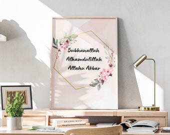 May include: A framed print with a pink and white watercolor background featuring a gold geometric frame with floral accents. The text inside the frame reads "Subhanallah Alhamdulillah Allahu Akbar".