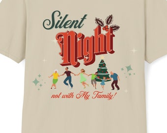 May include: Beige t-shirt featuring the text "Silent Night" in red and green, with a Christmas tree and people dancing around it. The text "not with My Family!" is below the main text.