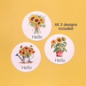 May include: Three circular stickers featuring sunflower illustrations and the text Hello. One shows a bouquet, one a watering can with flowers, and one a potted plant. The text All 3 designs included is printed in black near the top right.