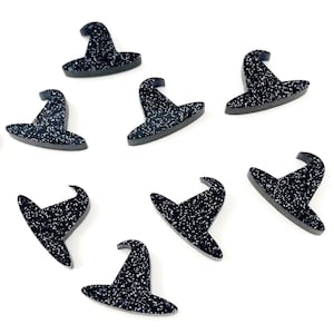 May include: Ten black witch hats with glitter accents. The hats are made of a black material and have a pointed top. They are scattered on a white surface.