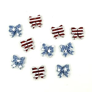 May include: Ten red, white, and blue glitter bows with a star pattern. Five bows have red and white stripes and five bows have blue and white stars.