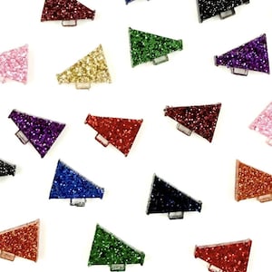 May include: A selection of glittery megaphone-shaped embellishments in various colours, including red, pink, gold, green, purple, and blue. Each megaphone has a small, rectangular handle. The items are scattered on a white background.