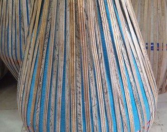 Könnte beinhalten: Eine große, runde, blaue und braune Trommel mit einem gewebten Muster. Die Trommel ist aus Holz und hat eine Lederhaut.