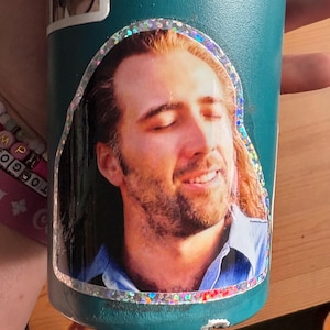 Nic Cage Con Air Cameron Poe Glitterklistermärke - Rolig hållbar vinyl (7,5 x 7,5 cm)