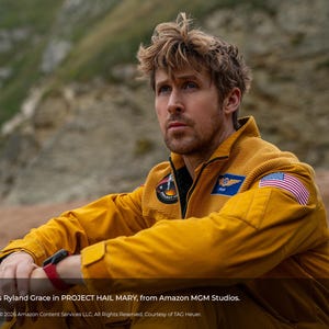 May include: A man wearing a mustard yellow jumpsuit with an American flag patch on the shoulder. The image includes text that reads "Ryan Gosling stars as Ryland Grace in PROJECT HAIL MARY, from Amazon MGM Studios."