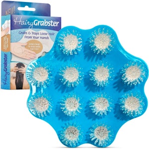 May include: A blue plastic hair catcher with white bristles. The hair catcher is shaped like a flower with 12 bristles. The product is called "Hairy Grabster" and the text "Grabs & Traps Loose Hair From Your Hands" is printed on the packaging.