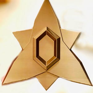 May include: A gold-colored, six-pointed star with a smaller, hexagonal shape in the center. The star has a slightly textured surface.