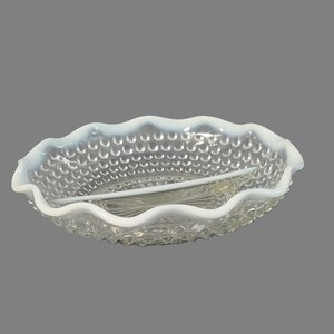 May include: A white milk glass divided serving dish with a scalloped edge and a textured, raised dot pattern.