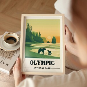 May include: A framed print of a vintage travel poster for Olympic National Park. The poster features a green and yellow color scheme with a silhouette of a mountain range, a beach, and two bears. The text "OLYMPIC NATIONAL PARK" is printed in black at the bottom of the poster.