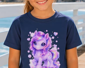 May include: A navy blue short-sleeved t-shirt featuring a graphic of a purple and pink unicorn surrounded by small bubbles and hearts. The shirt has a crew neckline and is paired with white drawstring shorts. The text COMFORT COLORS is visible.