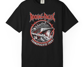 May include: A black short-sleeve t-shirt featuring a graphic of a cruise ship sailing through waves. The design includes the red and white text 'ROCKIN THE PACIFIC' at the top and 'TRANSPACIFIC TOUR' at the bottom, with the year '26' centered.