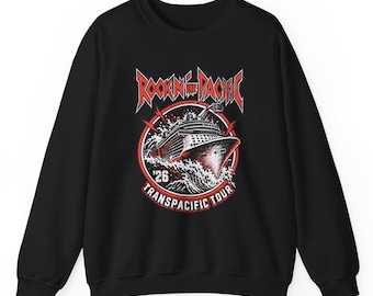 May include: A black crewneck sweatshirt featuring a graphic print of a cruise ship sailing through waves. The text reads Rockin the Pacific and Transpacific Tour with the number 26. The design uses red, white, and black colors in a circular frame.