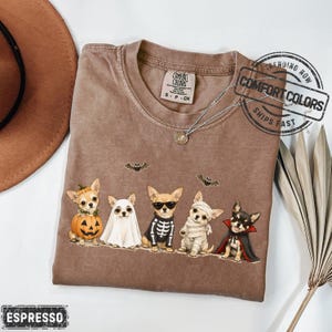Chihuahuas in Costumes Halloween Comfort Colors Shirt featuring Five Chihuahuas and Jack-o'-lantern pumpkin costume illustration across the front. This design also works as a Halloween Party Tshirt, Watercolor Illustration Graphic Tee, or Halloween Lover Gift.-Espresso