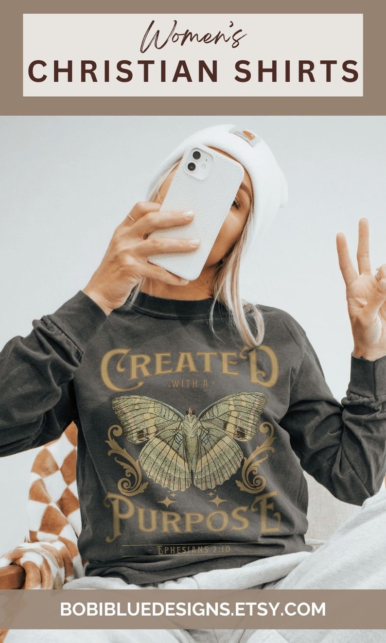 May include: A grey long-sleeved shirt with a butterfly graphic and the text "Created with a Purpose - Ephesians 2:10".
