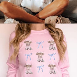 May include: Three different color sweatshirts featuring a cowgirl design with a cow wearing a pink sweater and a blue bow. The text "Coquette COWGIRL SWEARSHIRTS" is at the top of the image. The text "BOBIBLUEDESIGNS.ETSY.COM" is at the bottom of the image.