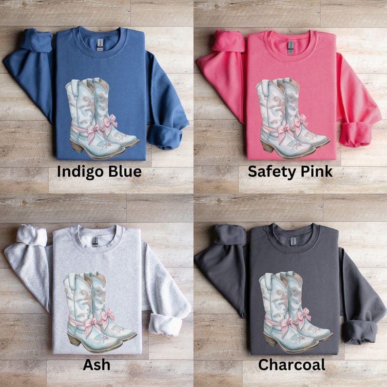 May include: Four different color sweatshirts with a graphic of a pair of light blue cowboy boots with pink bows. The sweatshirts are in indigo blue, safety pink, ash, and charcoal.