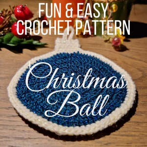 May include: A blue and white crocheted Christmas bauble ornament. The bauble is decorated with glitter and has a white crocheted border.