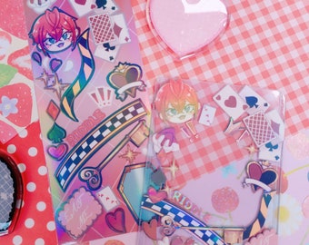 May include: Two clear plastic sheets with colorful stickers featuring a cartoon character with red hair and the word "Riddle". The stickers are on a pink and white checkered background.