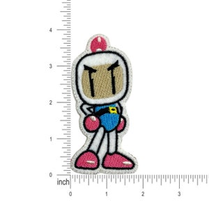 May include: Embroidered iron-on patch featuring a white, blue, and pink character with a brown face and angry eyebrows. The character is wearing a blue and white uniform with a yellow belt. The patch is approximately 2 inches tall.