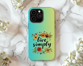 May include: A smartphone case with a gradient of green and blue. The case features a floral design with the words "live simply" in black script. The case is surrounded by white flowers and rests on a marble surface.