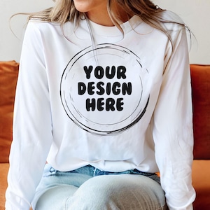 May include: A white long-sleeved sweatshirt with a black circle design that says "YOUR DESIGN HERE" in a bold font.