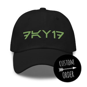 May include: Black baseball cap with a green embroidered logo that says "7KY17".