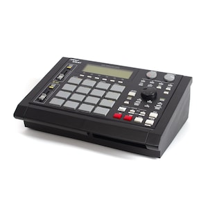 May include: A black Roland TR-808 Rhythm Composer drum machine with 16 pads, a display screen, and various knobs and buttons.