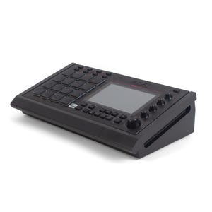 May include: Black Akai MPC Studio music production controller. The device features a grid of 16 pads, a central display screen, and various knobs and buttons. The Akai logo is visible in red on the top.