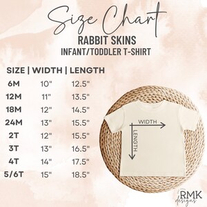 以下が含まれることがあります： Rabbit Skinsの乳幼児用Tシャツのサイズ表。6Mから5/6Tまでのサイズと、インチ単位の幅と長さの測定値が記載されています。クリーム色のTシャツが描かれており、幅と長さを指す矢印が表示されています。