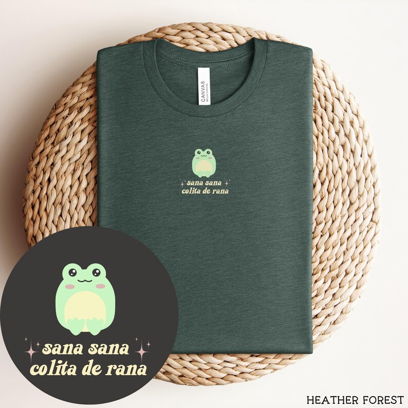 May include: A dark green t-shirt with a cartoon frog and the text "sana sana colita de rana" in yellow.