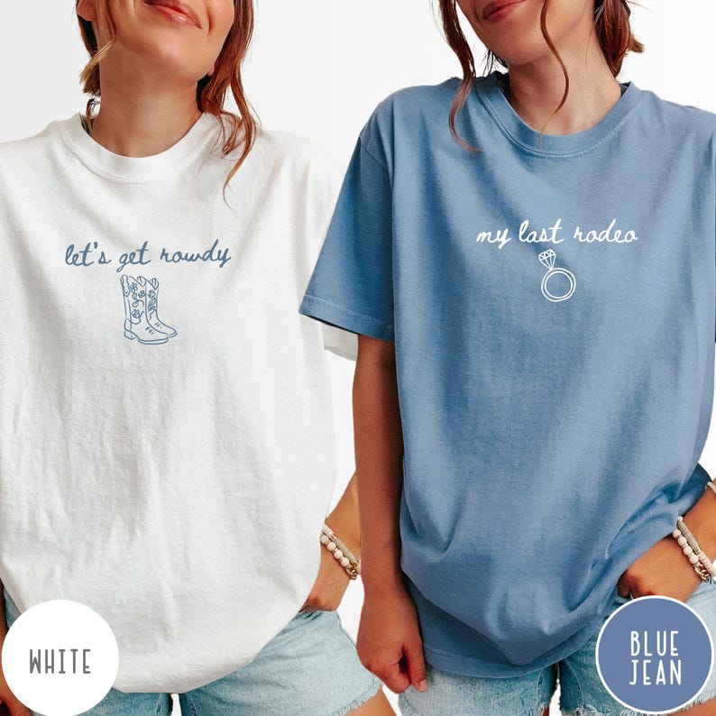 May include: A white t-shirt with blue text reading let's get rowdy and a line drawing of cowboy boots, and a blue t-shirt with white text reading my last rodeo and a line drawing of a diamond ring, both featuring short sleeves and crew necks.