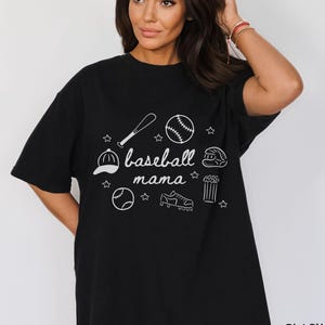 Puede incluir: Camiseta negra con un dise&ntilde;o gr&aacute;fico blanco de equipo de b&eacute;isbol y el texto "baseball mama".