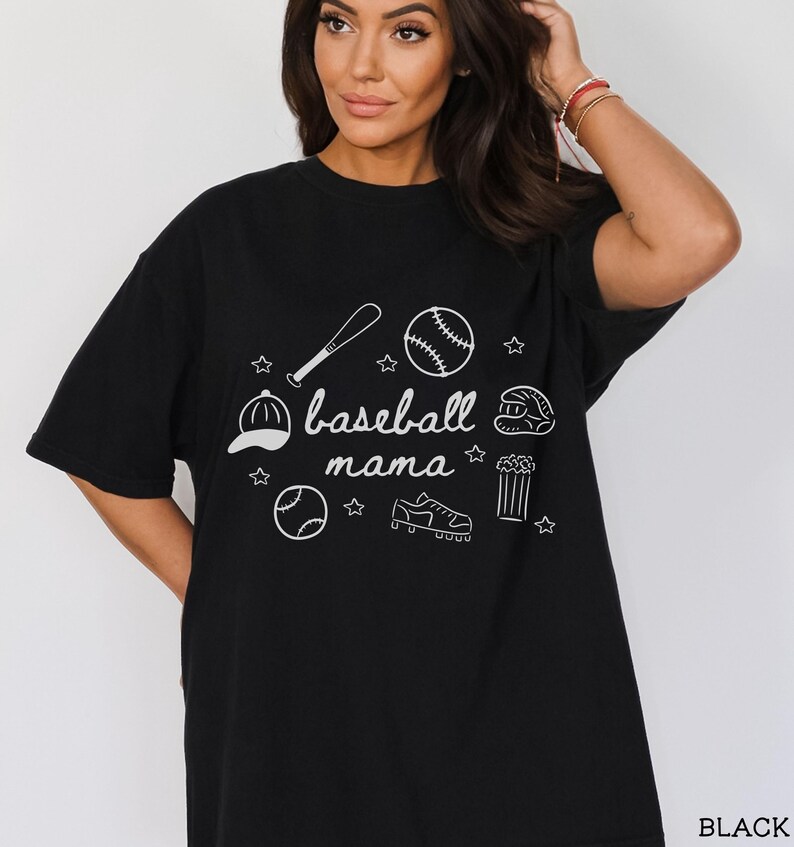 Puede incluir: Camiseta negra con un dise&ntilde;o gr&aacute;fico blanco de equipo de b&eacute;isbol y el texto "baseball mama".