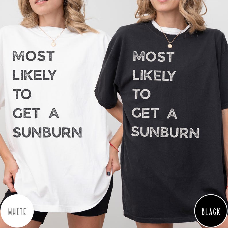 Puede incluir: Una camiseta blanca y una camiseta negra, cada una con el texto MOST LIKELY TO GET A SUNBURN impreso en una fuente oscura y desgastada. Ambas camisetas tienen cuello redondo y mangas cortas, presentadas juntas para comparar.