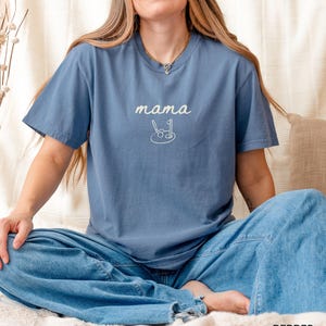 May include: A blue t-shirt with the text "mama" and a golf club and ball graphic.