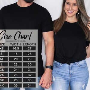 Pu&ograve; includere: Una tabella delle taglie per t-shirt nera con misure in pollici, che elenca le taglie dalla XS alla 4X con le relative dimensioni di larghezza e lunghezza. La tabella mostra valori di larghezza da 16,5 a 30 pollici e lunghezza da 27 a 34 pollici.
