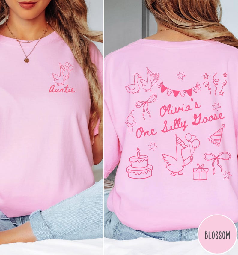 Op de afbeelding: Roze t-shirt met een afbeelding van een gans met ballonnen en het woord "Auntie" op de voorkant. De achterkant heeft een verjaardagsontwerp met de tekst "Olivia's One Silly Goose" en versieringen.