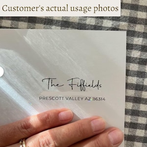 Pu&ograve; includere: Una carta bianca con il testo "The Fiffields" in corsivo e l'indirizzo "PRESCOTT VALLEY AZ 86314". La carta &egrave; tenuta in mano, con uno sfondo a scacchi.