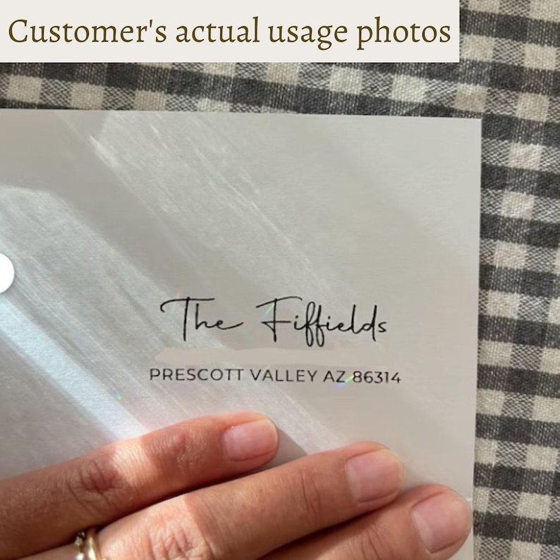 Pu&ograve; includere: Una carta bianca con il testo "The Fiffields" in corsivo e l'indirizzo "PRESCOTT VALLEY AZ 86314". La carta &egrave; tenuta in mano, con uno sfondo a scacchi.