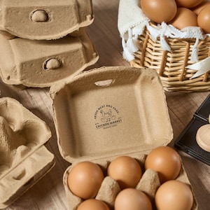 K&ouml;nnte beinhalten: Ein brauner Eierkarton aus Pappe mit sechs braunen Eiern darin. Der Karton tr&auml;gt ein Logo mit der Aufschrift "Fresh Meat and Eggs from Chicken Market Organic Farm".