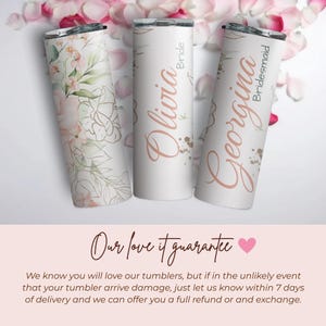 May include: Three stainless steel tumblers with lids. One features a floral design, while the others are white with rose gold text that reads "Olivia Bride" and "Georgina Bridesmaid". The tumblers are decorated with gold accents.