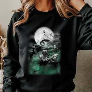 K&ouml;nnte beinhalten: Schwarzes Sweatshirt mit einem gr&uuml;n-wei&szlig;en Grafikdruck eines Charakters aus dem Film "Nightmare Before Christmas".