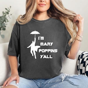 May include: A dark gray t-shirt with a white graphic of a person holding an umbrella and the text "I'm Mary Poppins Y'all".