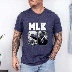 May include: A navy blue t-shirt with a white graphic of Martin Luther King Jr. and the text "MLK 68".