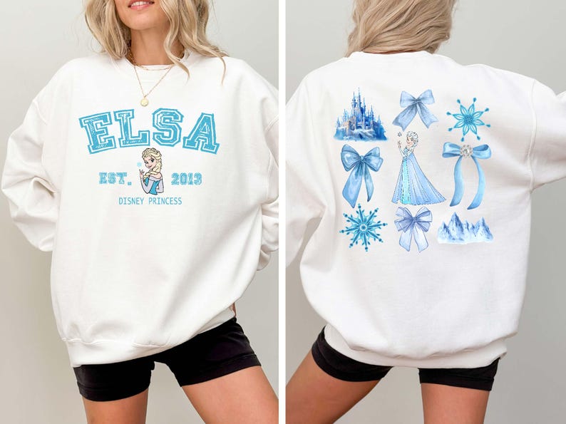 Elsa two sided bow sweatshirt and hoodie inspired by Frozen Disney princess style. Cozy unisex crewneck sweatshirt featuring front and back bow design aesthetic. Perfect Disney girls trip sweatshirt for Disneyland and Disney World vacations. Soft and comfortable Disney sweatshirt ideal for park outfits, travel days, or casual wear. Cute coquette Elsa sweatshirt great for girls, friends, and Disney fans.