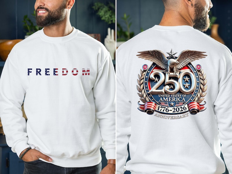 May include: White sweatshirt with the word "FREEDOM" in blue, white, and red lettering across the chest. The back features a detailed graphic commemorating the 250th anniversary of the United States of America, 1776-2026.