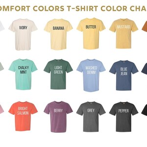 May include: A Comfort Colors t-shirt color chart displaying eighteen short-sleeve shirts in various shades including white, ivory, banana, butter, mustard, yam, bay, chalky mint, light green, washed denim, blue jean, denim, blossom, bright salmon, berry, grey, pepper, and black.